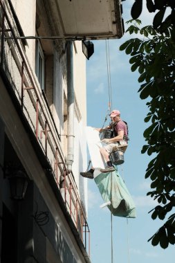 Zhytomyr, Ukrayna - 20 Temmuz 2020: Dış duvar panelinin termal yalıtımı. İşçi, yüksek duvarlı bina yalıtıyor..