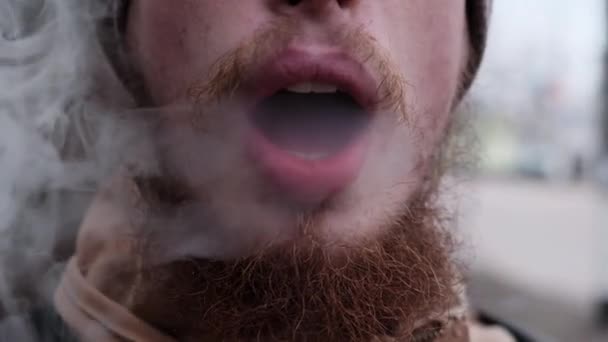 Close-up uitzicht van bebaarde blanke man roken weinig sigaar in de winter dag — Stockvideo