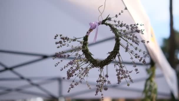 Lavendel krans hængende fra et telt på en festival – Stock-video