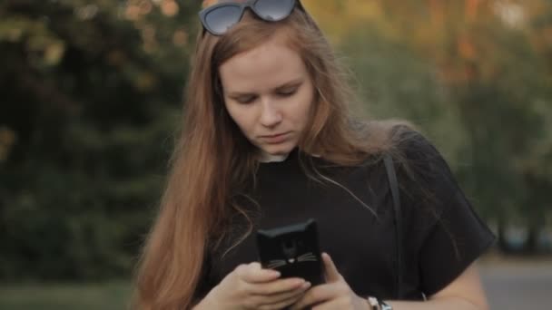 Zblízka mladý nervózní zázvor žena drží telefon v rukou při západu slunce — Stock video