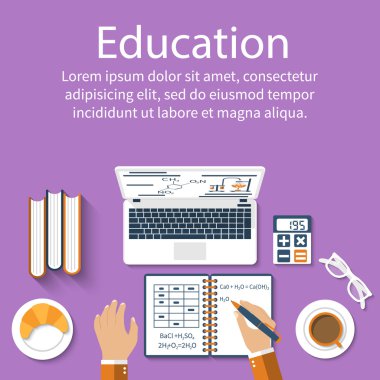 Student writes in notebook. Top view of table with supplies for 
