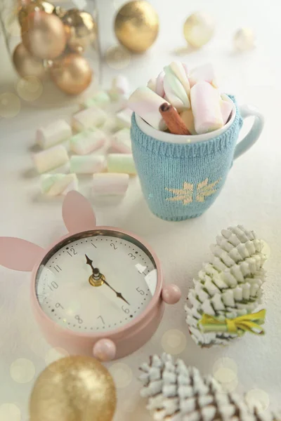 Ładny kubek ozdobiony różowym piankowym i różowym zegarem, dekoracje świąteczne. czas przed imprezą. smaczne słodycze i kubek z cynamonem. — Zdjęcie stockowe