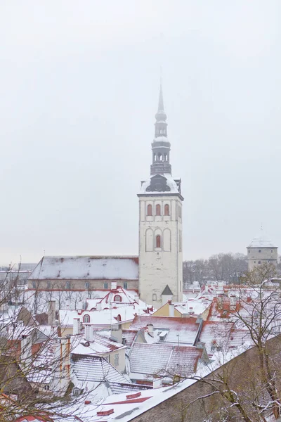 Παλιά πόλη του Ταλίν στην Εσθονία. Κάθετη φωτογραφία της εκκλησίας του Αγίου Νικολάου, Niguliste πρόσοψη και στέγες της παλιάς πόλης το χειμώνα — Φωτογραφία Αρχείου