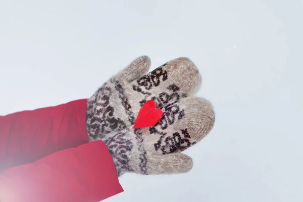 Red origami heart on hands at winter time.Snow and Heart in hands. art of paper folding — Stock Photo, Image