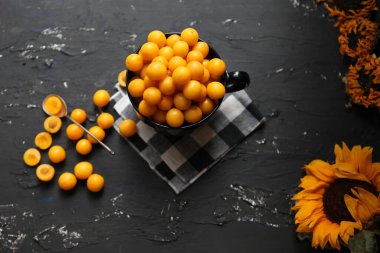 Siyah arka planda sarı erikler. Reçel için gerekli malzemeler. Yemek fotoğrafçılığı. Sarı ayçiçeği, üst manzara. Sonbahar Konsepti,