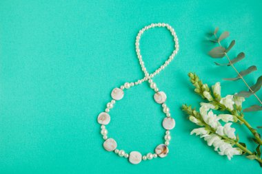 Yeşilimsi kağıttan arka planda beyaz çiçekli sekiz rakamlı şekil şekli. Uluslararası Kadınlar Günü kartı. Kadınların Bağımsızlık Günü - Bahar Çiçeği Konsepti