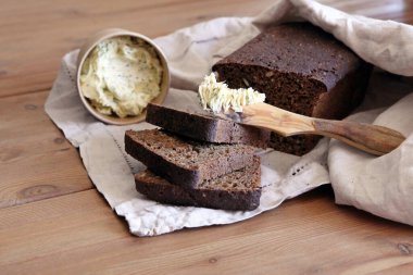 Taze ekmek dilimi ve kırsal masada bıçak kesme.