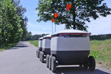 Teslimat robotlarını yolda hareket ettiriyorlar. Siber kuryeler Estonya 'da kaldırımlarda dolaşıyorlar. Tasarım için alanı kopyala. Modern dağıtım konsepti: Robot teslimatı..