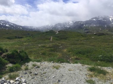 Norveç 'in dağlarındaki güzel kepçe. Dağlarda kar. İskandinav gökyüzü.