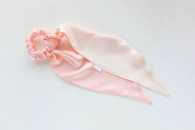 Pembe ipek Scrunchy beyaz üzerine izole edilmiş. Düz bir kuaför ve aksesuar. Saç tokası, elastik saç bandı, saç tokası, saç tokası. Saç tokası olarak sabitlenmiş eşarp