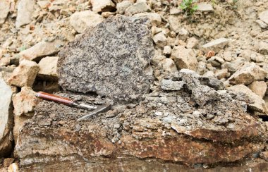 Jeologlar fosforit - Jeolojik alan çalışması üzerinde çalışıyorlar. Jeologlar çekiç, kaya çekici, kaya kıracağı ya da jeolojik kazma taşları parçalamak ve kırmak için kullanılır.