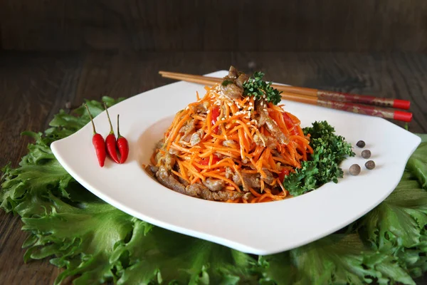 Karotte koreanischer Fleischsalat mit Stäbchen auf Eichentisch — Stockfoto