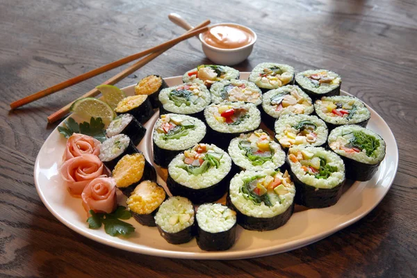 Gran conjunto con sushi y rollos. conjuntos de grandes rollos de tamaño en placas blancas. plato enorme con shushi — Foto de Stock