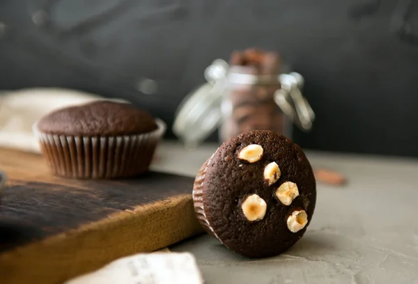 Magdalenas de chocolate con nueces en una mesa de madera. delicioso postre dulce. estilo rústico. — Foto de Stock