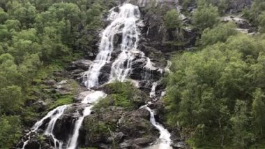 Yağmurlu havada Norveç dağlarına düşer. Norveç doğası ve seyahat geçmişi. Beyaz şelale. Voss, Norveç yakınlarındaki Tvindefossen Şelalesi.