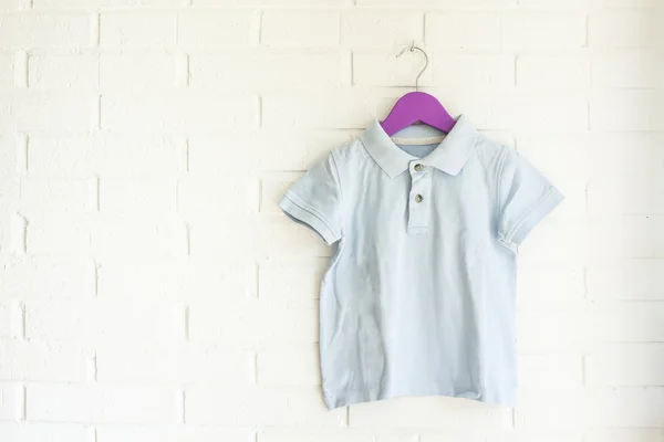 Blue polo shirt hanging on a purple hanger