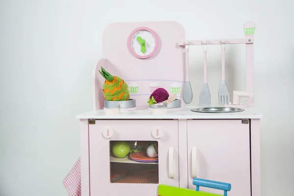 Juguete de cocina rosa para niños con utensilios, comida y un reloj en una w —  Fotos de Stock