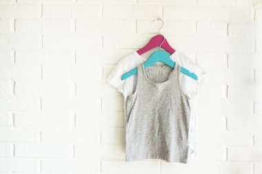 Gri kolsuz bluz ve bir aguamarine ve bir pi üzerinde asılı beyaz tshirt