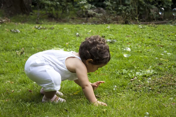 Flicka som leker med såpbubblor i trädgården — Stockfoto