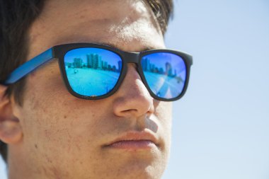 Büyük mavi ayna güneş giyen bir genç çocuk portresi kapatın 