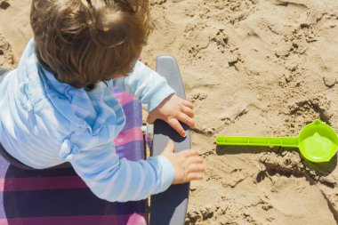 Yüksek açısı plastik sandalye ve bir kürek oyuncak bebek çocuk oturup shot