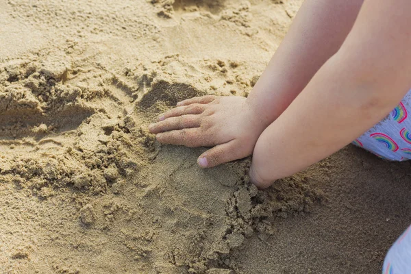 Ragazze mani che giocano nella sabbia in spiaggia . — Foto Stock