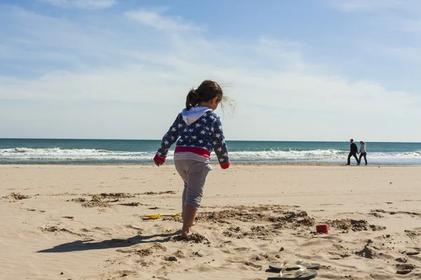 Retrovisore full shot ragazza a piedi verso la riva della spiaggia in un — Foto Stock