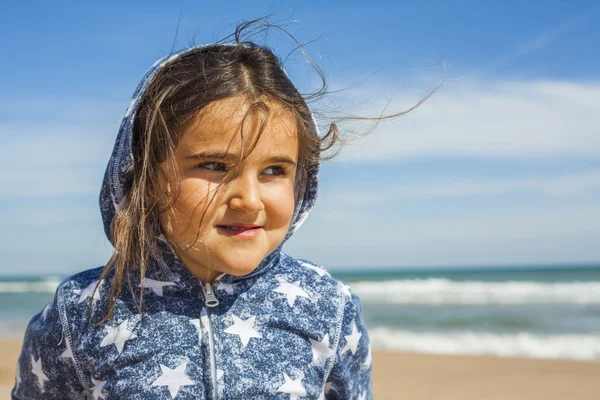 Close up ragazza sorridente in posa in spiaggia in una giornata ventosa a Pasqua — Foto Stock