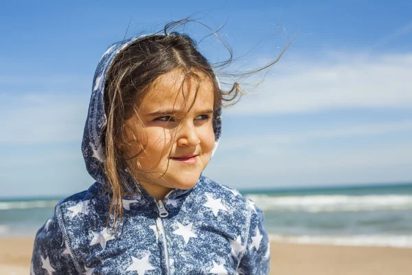 Close up ragazza sorridente in posa in spiaggia in una giornata ventosa a Pasqua — Foto Stock