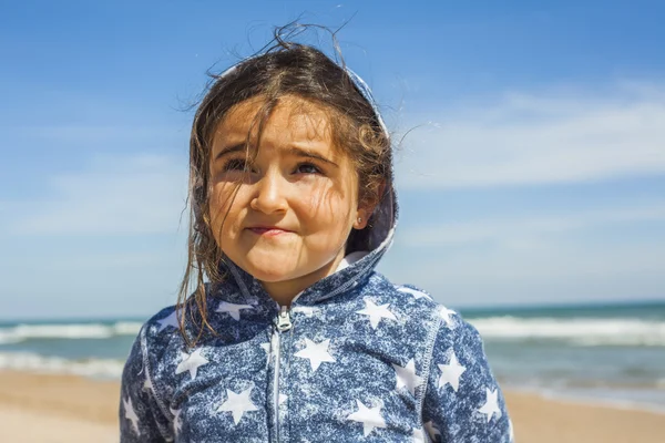 イースターで風の強い日にビーチでポーズをとって smily の女の子を閉じる — ストック写真