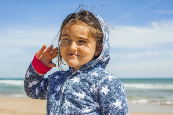 Close up ragazza sorridente in posa in spiaggia in una giornata ventosa a Pasqua — Foto Stock