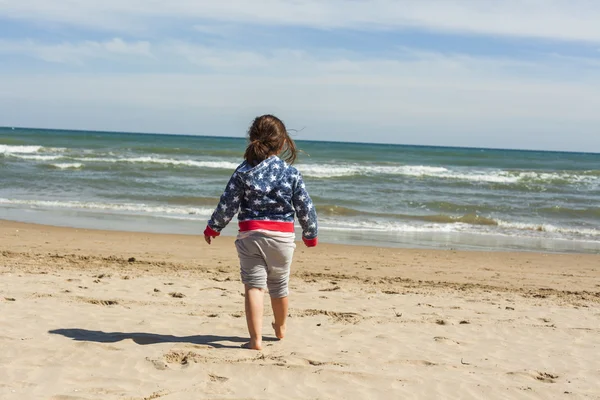 Retrovisore full shot ragazza a piedi verso la riva della spiaggia in un — Foto Stock