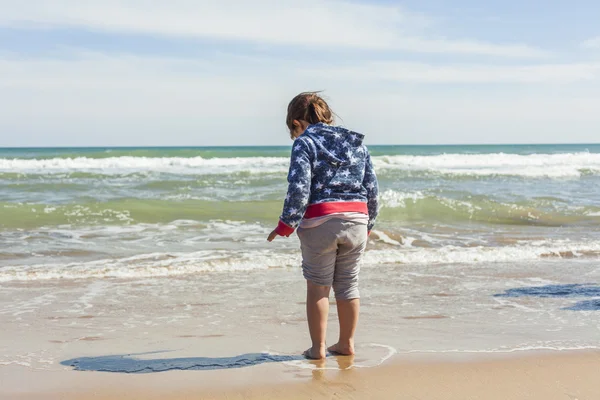 Retrovisore full shot ragazza a piedi verso la riva della spiaggia in un — Foto Stock