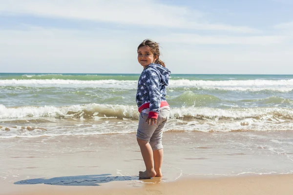 Retrovisore full shot ragazza a piedi verso la riva della spiaggia in un — Foto Stock