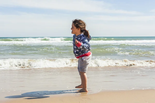 Menina tiro completo correndo na costa da praia em um dia ensolarado — Fotografia de Stock