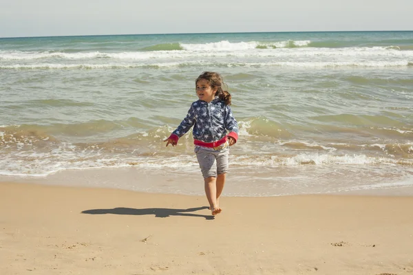 Ragazza full shot che corre sulla riva della spiaggia in una giornata di sole — Foto Stock