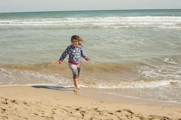 Ragazza full shot che corre sulla riva della spiaggia in una giornata di sole — Foto Stock