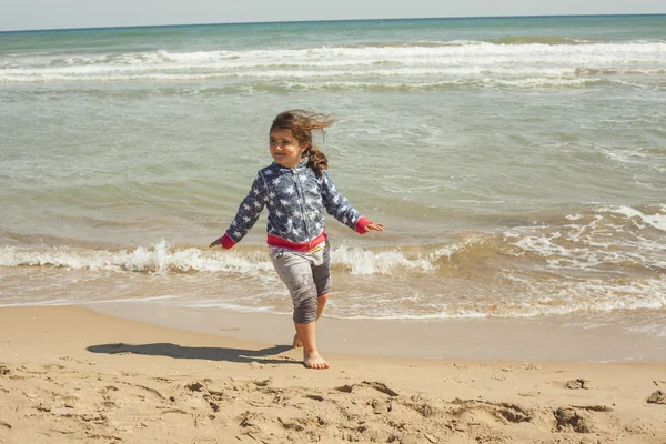 Ragazza full shot che corre sulla riva della spiaggia in una giornata di sole — Foto Stock