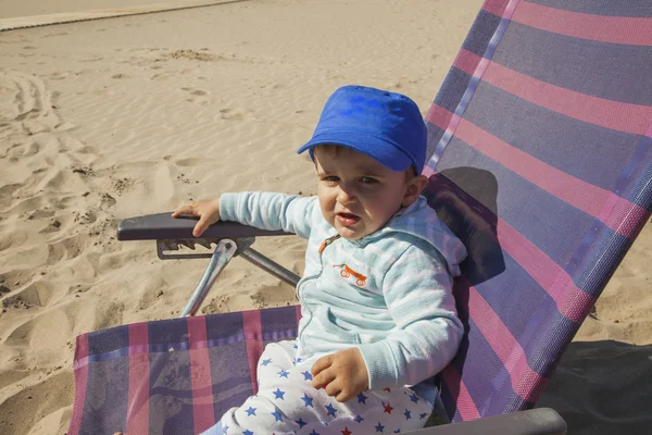 Medium schoot babyjongen met een blauwe dop zit in een plastic stoel op t — Stockfoto
