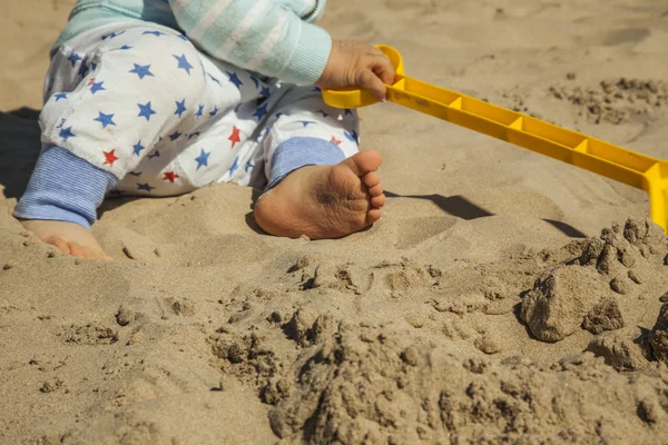 ビーチで砂のおもちゃで遊ぶ男の子の赤ちゃんを閉じる. — ストック写真