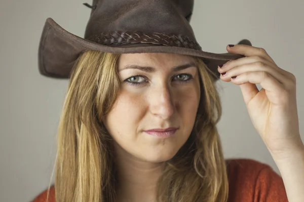 Retrato de la hermosa mujer rubia con un sombrero de vaquero disparar en st — Foto de Stock