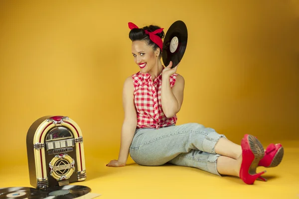 Portrait beautiful pin up listening to music on an old jukebox r — Stock Photo, Image