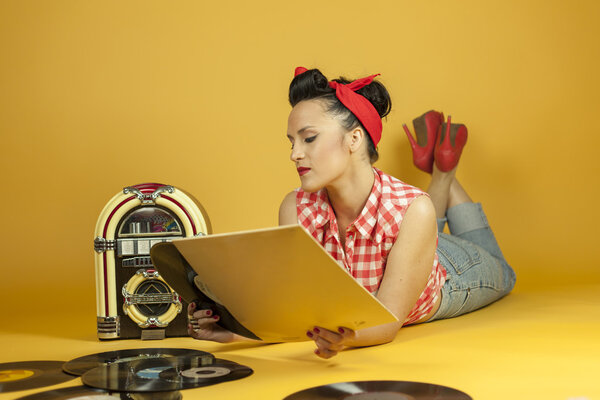 Portrait beautiful pin up listening to music on an old jukebox r