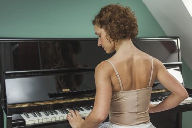 Performans ve bir evde piyano arka görünümü balerin