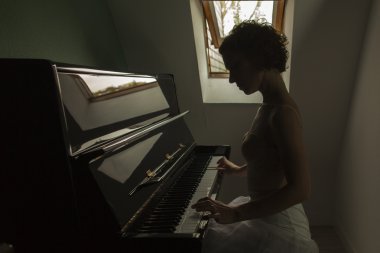 Performans ve bir evde piyano balerin. Arka ışık