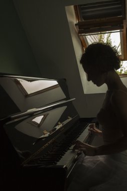 Performans ve bir evde piyano balerin. Arka ışık