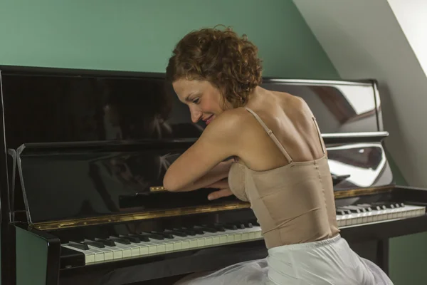 Bailarina vista trasera tocando y tocando el piano en una casa — Foto de Stock