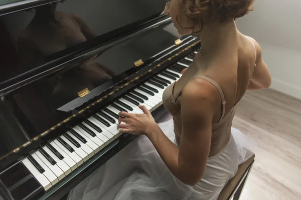 Ballerina utför och spela piano i ett hus — Stockfoto