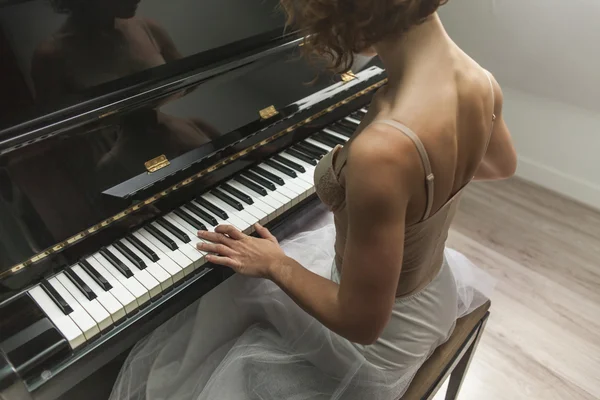 Ballerina performing and playing the piano in a house — Stock Photo, Image