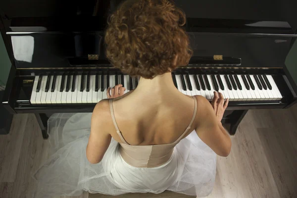 Rear view ballerina performing and playing the piano in a house — Stock Photo, Image